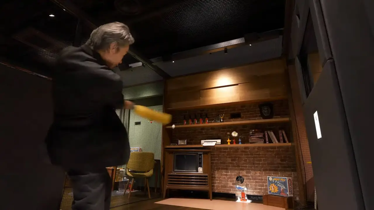 Nintendo Museum's batting cage with a man  swinging a bat