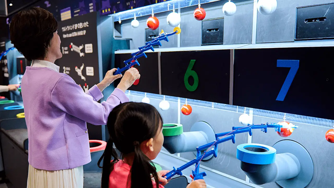 a grandma and grandchild playing a game with an extendable plastic hand