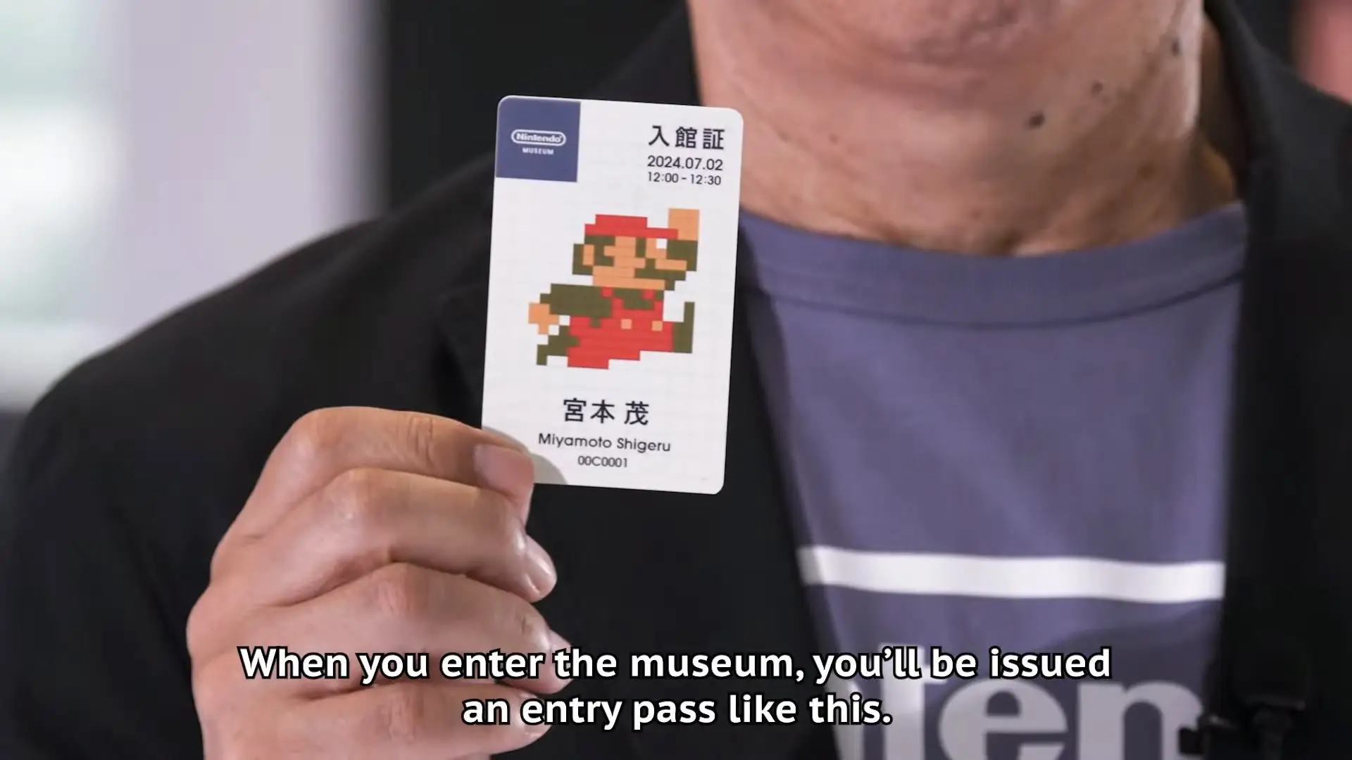 close up of a hand holding Nintendo Museum entry pass play ticket