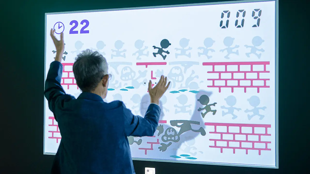 a guy playing a game on a screen with his shadow