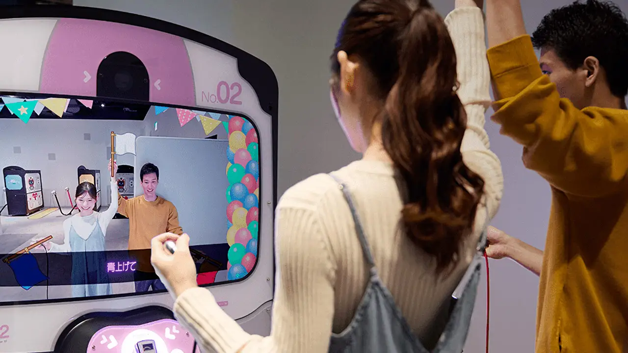 a guy and girl holding hands and looking a monitor